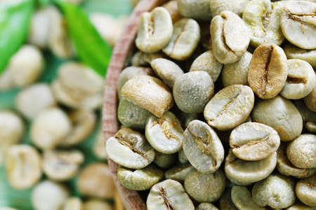 green coffee beans on a wooden background