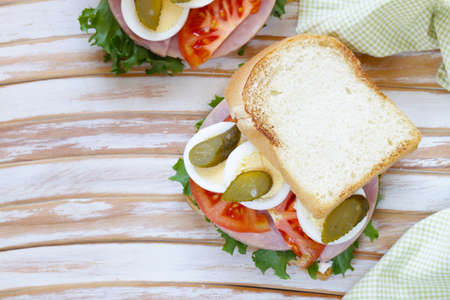 sandwich with ham, tomato, egg and picklesの写真素材