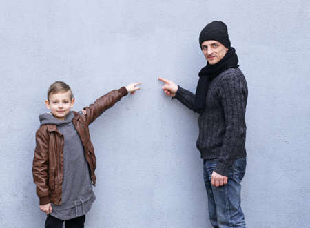 Man and boy (father and son) posing on a gray backgroundの写真素材