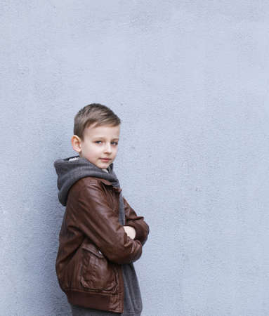 Cute blond boy posing on gray backgroundの写真素材