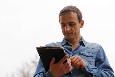 Portrait of a young man with an electronic tabletの写真素材
