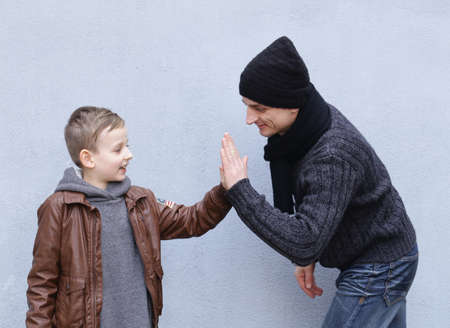 Man and boy (father and son) posing on a gray backgroundの写真素材