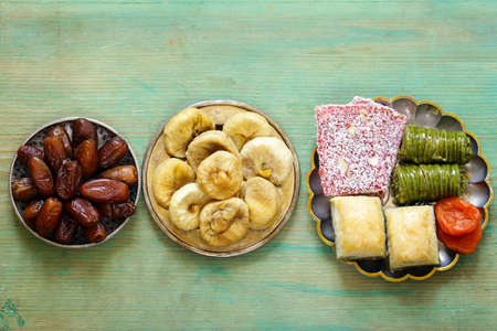 Eastern sweets (baklava, rahat loachum) and dried fruits on a silver plateの写真素材