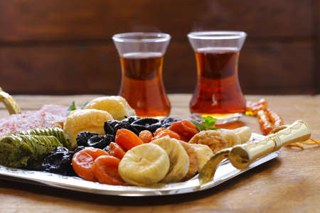 Eastern sweets (baklava, rahat loachum) and dried fruits on a silver plateの写真素材