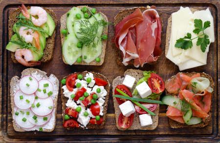 variety of sandwiches with different fillings (avocado, shrimp, fish, ham, vegetables)の写真素材