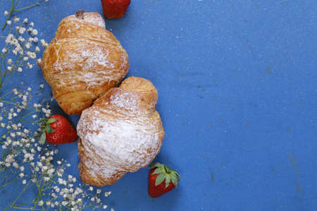 Croissants with powdered sugar and strawberriesの写真素材