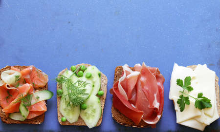 variety of sandwiches with different fillings (avocado, shrimp, fish, ham, vegetables)