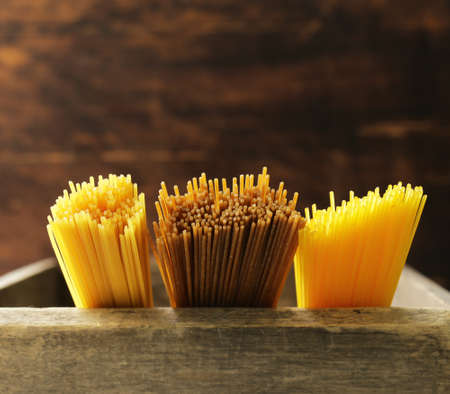 Traditional pasta spaghetti with tomatoes and herbs on a wooden tableの写真素材