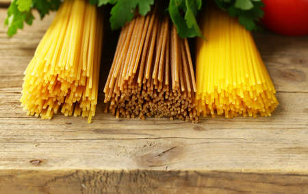 Traditional pasta spaghetti with tomatoes and herbs on a wooden tableの写真素材