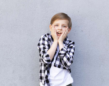 Cute blonde boy in casual clothes posing