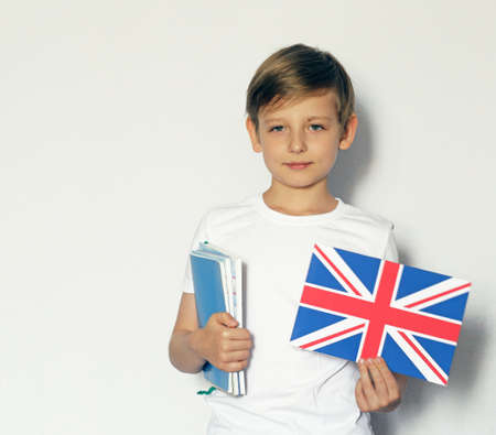 Cute blonde boy in casual clothes posing with british flagの写真素材
