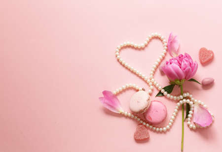 Pink background with flowers and macaroons, sweet and for womenの写真素材