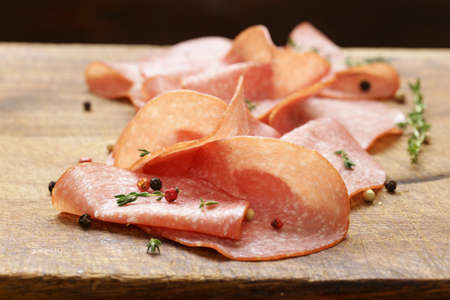 Sliced sausage salami with thyme and pepper