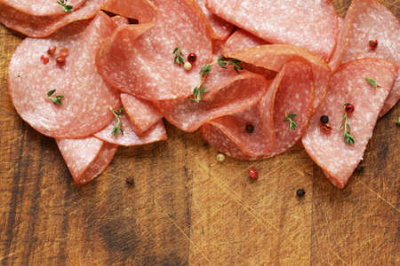 Sliced sausage salami with thyme and pepperの写真素材