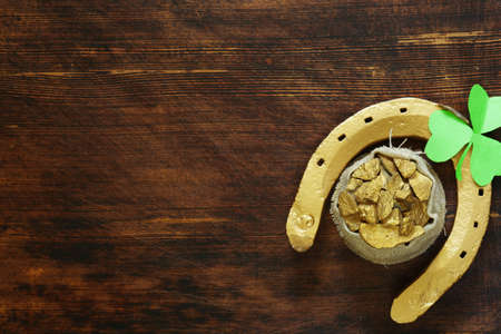 The symbol of St. Patrick's Day is a golden horseshoe and a cloverの写真素材