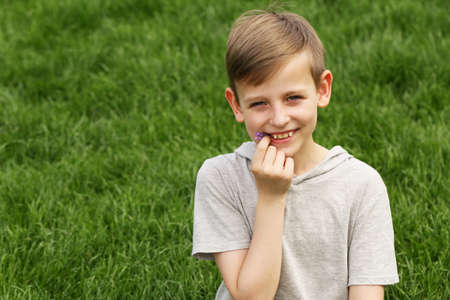 Cute young boy resting on the green grass - summer time, picnicの写真素材