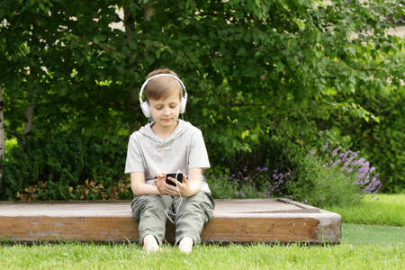 Cute young boy resting on the green grass - summer time, picnicの写真素材