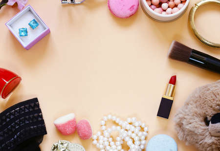 Cosmetics, decorations, sweets on a beige backgroundの写真素材