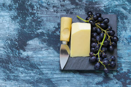 Snack cheese with fruit on a black boardの写真素材