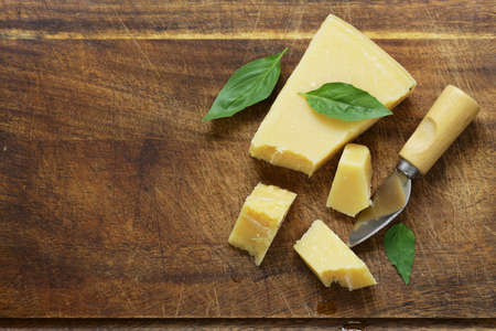 Hard Parmesan cheese on a wooden boardの写真素材