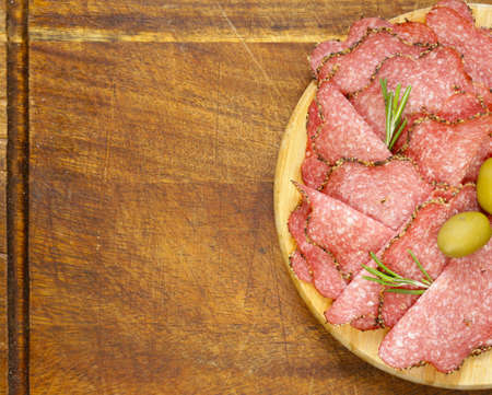 Salami pepperoni with aromatic pepper on a plateの写真素材