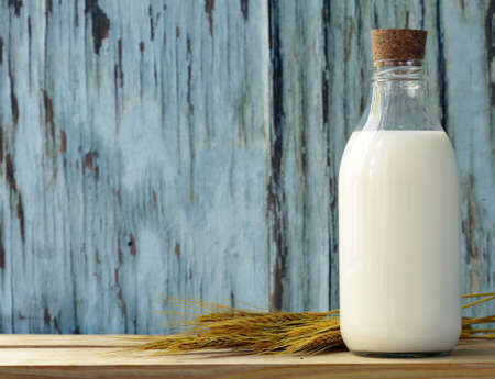 Organic milk in a glass bottle on a wooden tableの写真素材