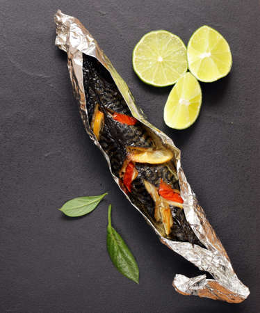 fish baked in foil with vegetables and lemonの写真素材