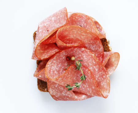 sliced sausage salami on a white backgroundの写真素材