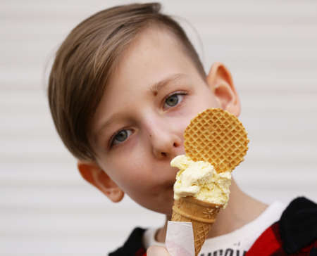 Cute young boy eating ice cream in waffle coneの写真素材