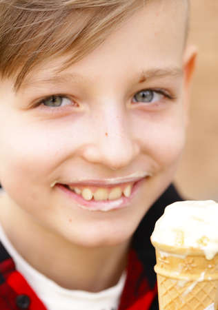 Cute young boy eating ice cream in waffle cone