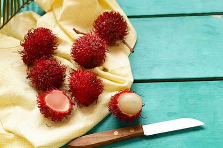 fresh tropical fruit rambutan on a wooden backgroundの写真素材