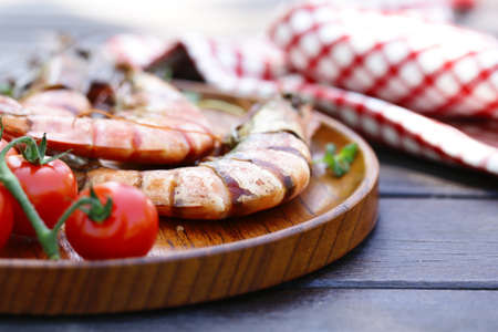 grilled large shrimp on a plate on a wooden tableの写真素材