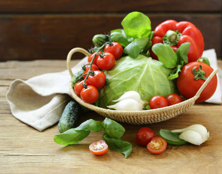 fresh spring vegetables in a basket on a wooden table