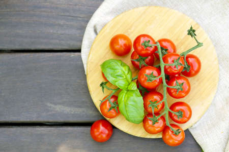 fresh tomatoes and basil on a wooden tableの写真素材