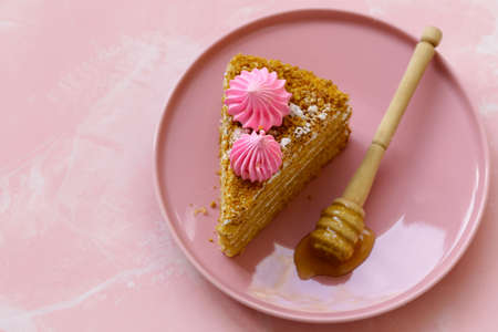 honey cake dessert on a plate on a pink background