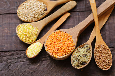 various cereals in wooden spoons - healthy food