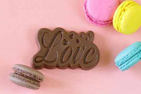 macaroons and chocolate love on a pink background