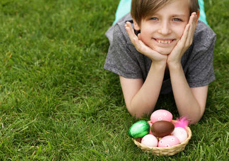 happy boy with festive easter eggs in the parkの写真素材