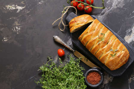 puff pastry pie with meat on a wooden board