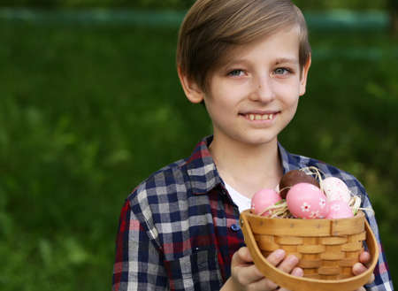 happy boy with festive easter eggs in the parkの写真素材