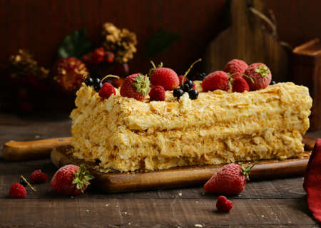 napoleon layered cake with berries on a wooden table