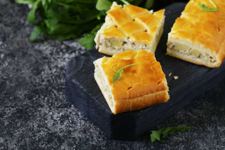 homemade pie with meat and potatoes on a wooden boardの写真素材