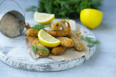 fried fish for lunch, with lemon and herbsの写真素材