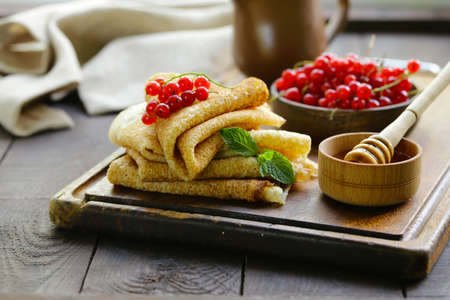 thin pancakes with berries and honey