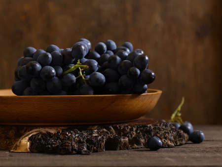 black ripe organic grapes on a wooden table, rustic styleの写真素材