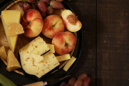 cheese, grapes and wine on a wooden table, rustic styleの写真素材