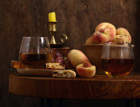 dessert white wine and biscotti on a wooden table
