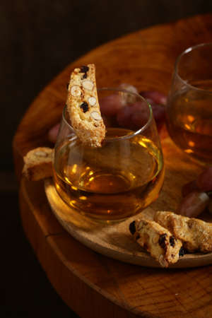 dessert white wine and biscotti on a wooden tableの写真素材