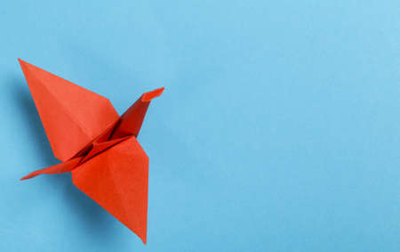origami paper crane on a blue backgroundの写真素材