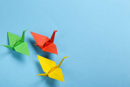 origami paper crane on a blue backgroundの写真素材
